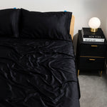 Black charcoal eucalyptus bamboo bed sheets styled on a modern bed. Luxurious, cooling bedding for hot sleepers seeking comfort and elegance.